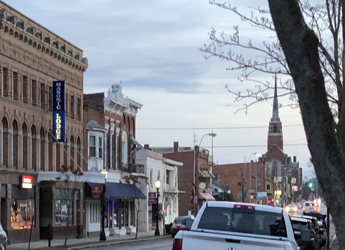 Brick storefronts and a church spire in downtown Tiffin